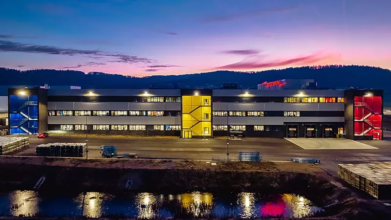 Industriegebäude bei Dämmerung mit Spiegelung im Wasser.